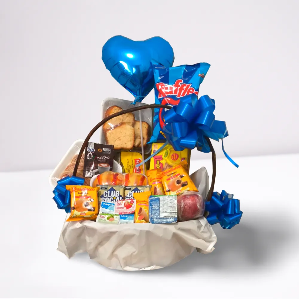 Cesta de café da manhã infantil masculino com chocolates, biscoitos, itens doces e balão azul.