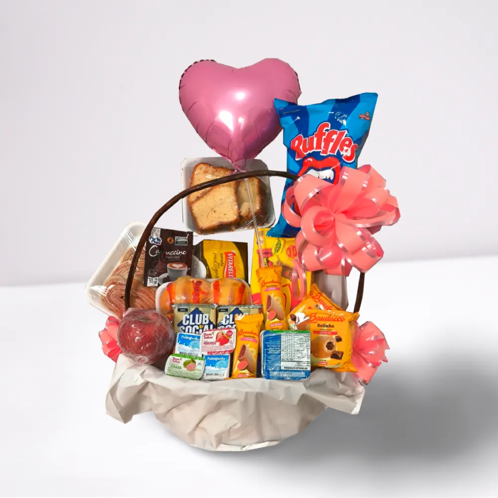 Cesta de café da manhã infantil para menina com balão em formato de coração, chocolates, biscoitos, suco e itens decorativos em cesta rústica.